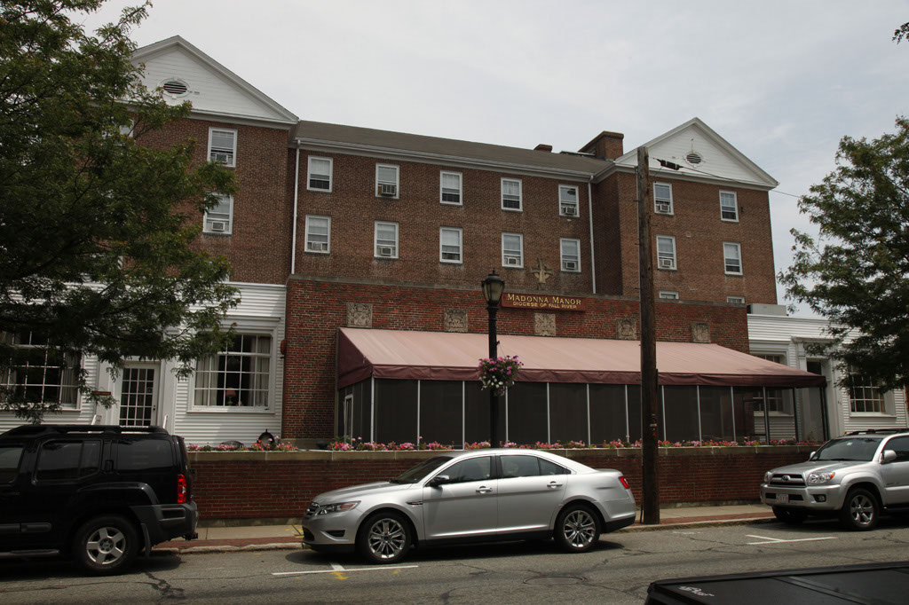 Madonna Manor brick building with parked cars
